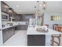 Modern kitchen featuring a large island, stainless steel appliances, and dark wood cabinetry at 2490 Southlawn Ln, Clermont, FL 34714