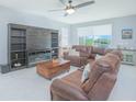 Spacious living room with comfortable leather seating, a fireplace, and scenic views at 2490 Southlawn Ln, Clermont, FL 34714