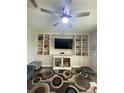 Comfortable living room features a ceiling fan, modern shelving, and media center at 2667 River Landing Dr, Sanford, FL 32771