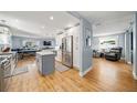 Open-concept kitchen with stainless steel appliances and hardwood flooring at 2707 Prince John Rd, Winter Park, FL 32792