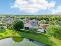 Stunning aerial view of a neighborhood with lush greenery and a peaceful pond at 3514 Forest Ridge Ln, Kissimmee, FL 34741