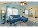 Bright living room featuring a cozy blue sectional sofa and large windows with natural light at 411 Hibiscus Rd, Casselberry, FL 32707