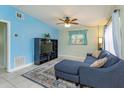 Open-concept living room with stylish blue accent wall, tiled floors, and a comfortable sectional sofa at 411 Hibiscus Rd, Casselberry, FL 32707