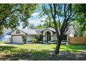 Well-kept one-story home with a two-car garage, manicured lawn, and arched entryway, exuding curb appeal at 485 Sandpiper Ridge Dr, Orlando, FL 32835