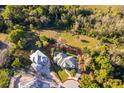 Aerial view showing a lovely landscaped home with a circular drive and mature trees at 516 Sanctuary Golf Pl, Apopka, FL 32712