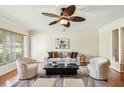 Bright living room with hardwood floors, a ceiling fan, neutral decor, and ample natural light from a large window at 600 Brechin Dr, Winter Park, FL 32792