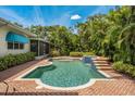 Stunning pool area surrounded by lush landscaping and a brick paver deck, perfect for outdoor entertaining and relaxation at 600 Brechin Dr, Winter Park, FL 32792