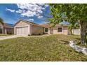 Charming single-story home with a large two car garage and a well-maintained front yard at 62 York Ct, Kissimmee, FL 34758