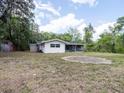 Spacious backyard view showing the home's rear exterior and surrounding trees at 633 Hermits Trail, Altamonte Springs, FL 32701