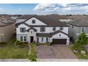 A beautiful aerial view of a two-story house, highlighting its landscaped front yard and brick driveway at 8109 Ludington Cir, Orlando, FL 32836