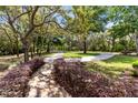 Manicured grounds with mature trees, garden bed, stone pathways and lighting at 840 Dyson Dr, Winter Springs, FL 32708