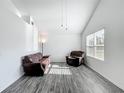 Bright living room with vaulted ceilings, wood floors, and large windows providing natural light at 12388 Se 106Th Ave, Belleview, FL 34420