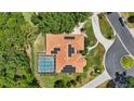 An aerial view shows the property with a private pool and solar panels on the roof at 128 Lake Region Cir, Winter Haven, FL 33881