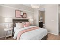 A serene bedroom featuring neutral tones, stylish decor, and a peek into the ensuite bathroom at 1302 Nestled Valley Rd, Minneola, FL 34715