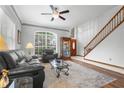 Bright and airy living room featuring a staircase, large windows, and stylish furnishings at 13640 Dornoch Dr, Orlando, FL 32828