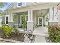 Inviting front porch with hanging plants, cozy seating and decorative accents creating a relaxing outdoor space at 14131 Paradise Tree Dr, Orlando, FL 32828