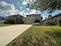 Well-maintained two-story home with a spacious driveway and lush green lawn at 15157 Pigeon Plum Ln, Winter Garden, FL 34787