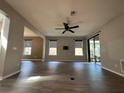 Spacious living room featuring wood-look tile flooring, modern ceiling fan, and sliding glass doors at 15157 Pigeon Plum Ln, Winter Garden, FL 34787