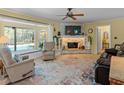 Inviting living room with a stone fireplace, large bay window overlooking the pool, and neutral-toned flooring at 210 Lonesome Pine Dr, Longwood, FL 32779