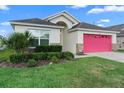 Charming single-Gathering home showcasing a well-manicured lawn and inviting red garage door at 2535 Oneida Loop, Kissimmee, FL 34747