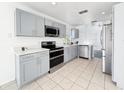 Modern kitchen with stainless steel appliances, gray cabinetry, and quartz countertops at 2601 Spring Hill Dr, Kissimmee, FL 34743