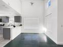 Open living area with sleek flooring, high ceilings, and a partial view of the modern kitchen at 2601 Spring Hill Dr, Kissimmee, FL 34743