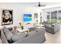 A cozy living room has comfortable gray sofas, a large TV, and a sliding glass door to the lanai at 2618 Calistoga Ave, Kissimmee, FL 34741