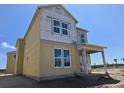 Newly constructed home with yellow siding and a covered front porch at 2963 Embark Trail, St Cloud, FL 34771