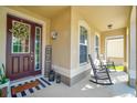Welcoming front porch with rocking chairs, decorative wreath, and a cozy, inviting ambiance at 3041 Cardillino Way, Kissimmee, FL 34741