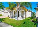 Beautiful home with palm trees and manicured lawn, complete with a charming front porch at 3041 Cardillino Way, Kissimmee, FL 34741