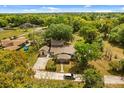 An aerial view of the home's surrounding landscape with lush greenery, a detached garage and ample parking at 3137 East St, Oviedo, FL 32765