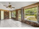 Enclosed brick sunroom offering ample natural light through large windows, tile flooring, and security door at 3137 East St, Oviedo, FL 32765