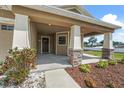 Welcoming front porch with stone-accented columns and landscaped flowerbeds, creating an inviting entrance at 5707 Fischer Dr, Lakeland, FL 33812
