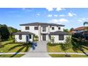 Beautiful modern two-story home with a paver driveway, manicured landscaping, and a striking front entrance, under a sunny blue sky at 5762 Emerington Cres, Orlando, FL 32819