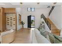 Bright living room with hardwood floors, high ceilings, modern staircase, and a view to the home's exterior at 5762 Emerington Cres, Orlando, FL 32819