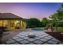Backyard patio with outdoor kitchen, fire pit, pool, and playground at 6143 Cartmel Ln, Windermere, FL 34786