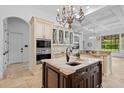 Gourmet kitchen features custom cabinets, island with sink, granite counters, and pendant lighting at 6143 Cartmel Ln, Windermere, FL 34786