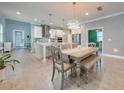 Open-concept kitchen and dining area with modern lighting and tile flooring at 6667 Alder Rd, Harmony, FL 34773