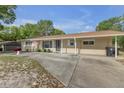 Single-story home with neutral paint, light trim, covered carport, and a well manicured lawn at 825 Second St, Orange City, FL 32763