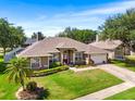 Inviting home with lush green lawn, mature trees, and a welcoming front entrance at 901 Cornell Ave, Clermont, FL 34711