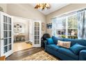 Cozy living room with a blue couch, large window, and french doors to dining room at 901 Cornell Ave, Clermont, FL 34711