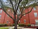 Red brick apartment building featuring mature trees and well-maintained grounds at 107 Vista Verdi Cir # 121, Lake Mary, FL 32746