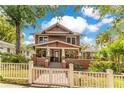 Beautiful home featuring a brick foundation, manicured lawn, and a charming white picket fence at 117 N Thornton Ave, Orlando, FL 32801