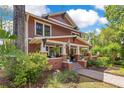 Charming two-story home features a brick walkway, lush landscaping, and a welcoming front porch at 117 N Thornton Ave, Orlando, FL 32801