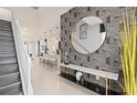 Stylish entryway with decorative wallpaper, modern console table, and open view into the kitchen and dining area at 15980 Cape Coral Loop, Clermont, FL 34714