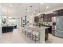 Open-concept kitchen with granite countertops, stainless steel appliances, and a breakfast bar with seating at 15980 Cape Coral Loop, Clermont, FL 34714