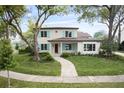 Beautiful two-story home showcases lush landscaping, a brick walkway, and stylish light blue shutters at 702 S Lake Adair Blvd, Orlando, FL 32804