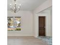 Bright foyer featuring a dark wooden door, marble flooring, and views of the outdoors at 702 S Lake Adair Blvd, Orlando, FL 32804
