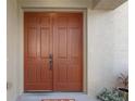 Close-up of the double front doors, featuring paneled detailing, a bronze handle, and a smart lock system at 9244 Pecky Cypress Way, Orlando, FL 32836