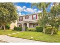Inviting two-story home with mature trees, red shutters, and a neatly kept lawn at 987 Alston Bay Blvd, Apopka, FL 32703